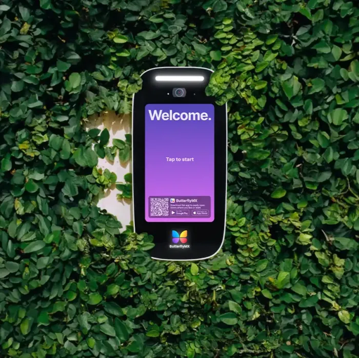 Video intercom mounted on a wall covered with greenery