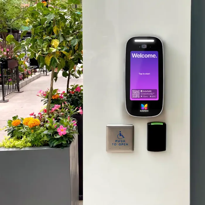Video intercom mounted on an exterior wall above mullion reader