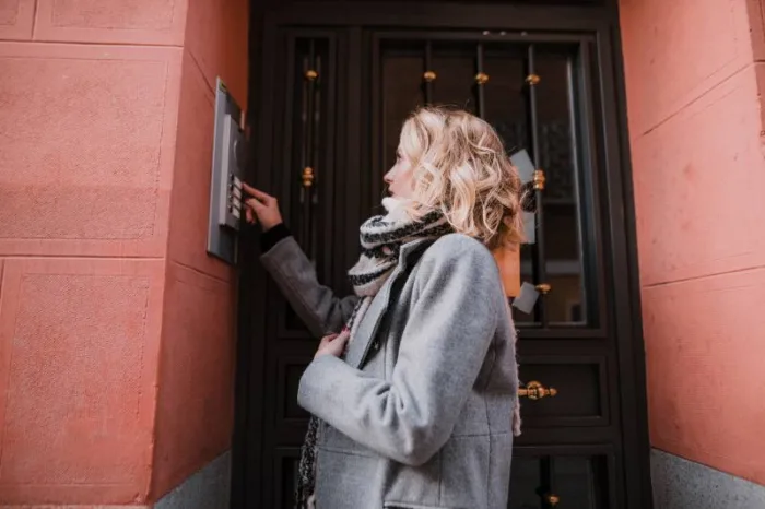 woman using apartment intercom system