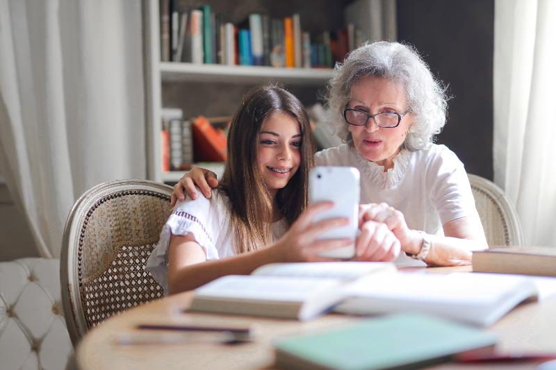 Grandma and granddaughter relax in a building managed by a senior housing manager