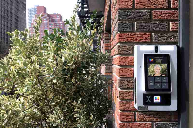 A smart intercom mounted on a brick wall