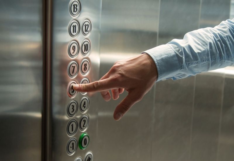 man pressing elevator button elevator brands