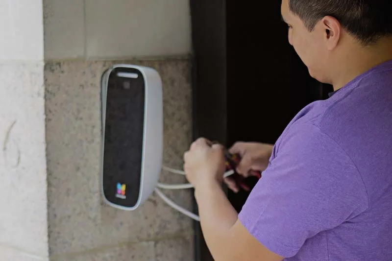 Installer mounts the ButterflyMX Video Intercom to the backplate