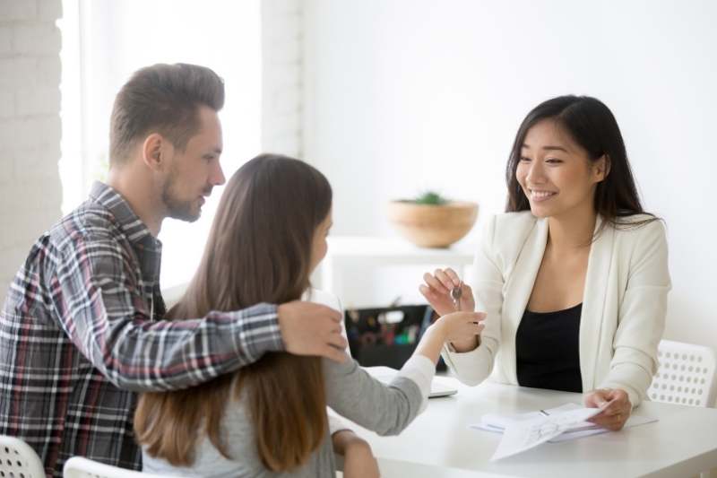 A commercial property manager hands over keys to a new tenant.