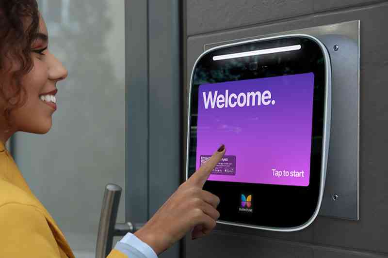 Woman using a door entry intercom system.