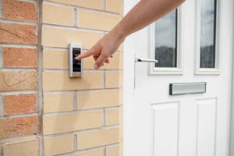 Visitor pressing doorbell that's connected to tenant's phone.