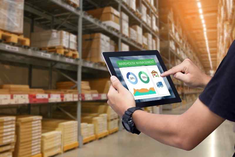 Man checking inventory at an industrial package fulfillment center..