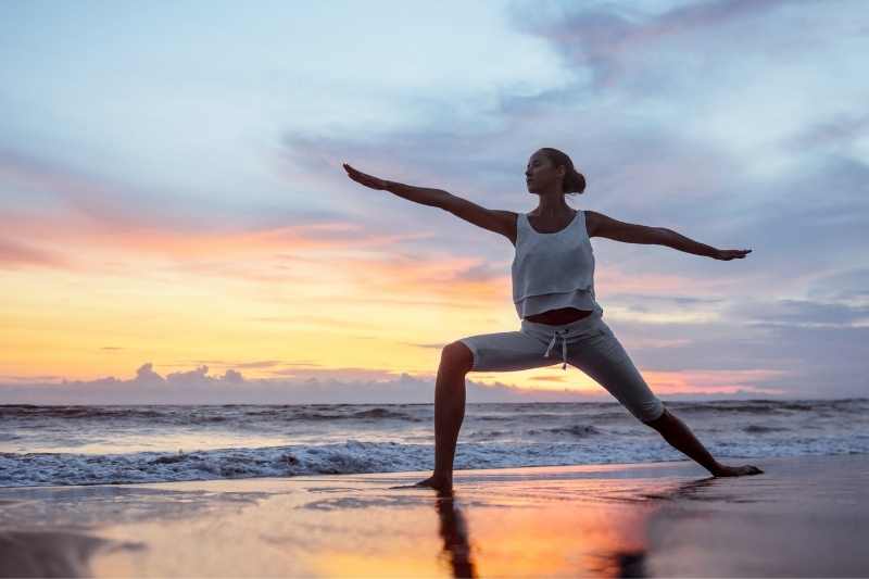 Women doing yoga on the beach near short-term rental.