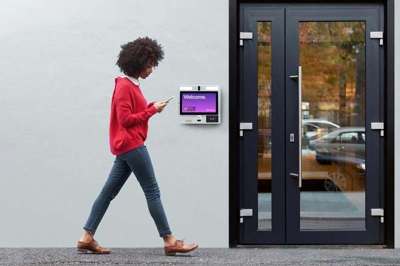 resident walking past building entrance with digital doorman system