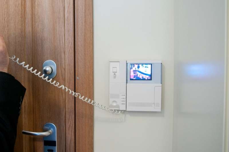 resident answering call on a door phone intercom system