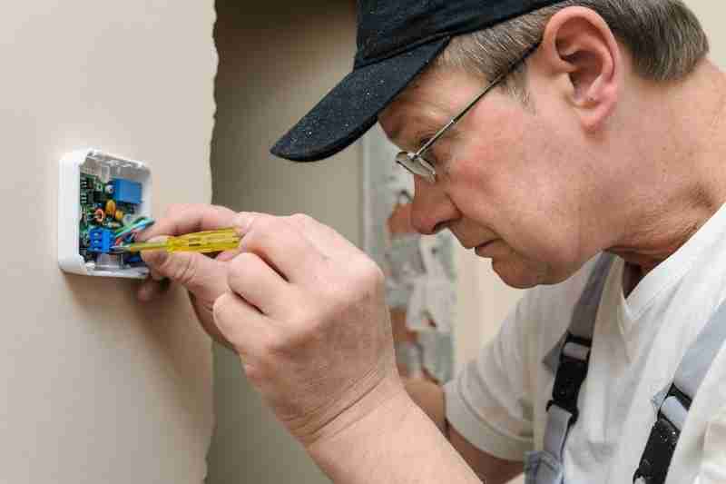 security integrator installing thermostat