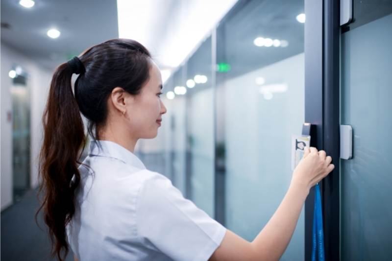 a woman uses a commercial key fob door lock system at her office