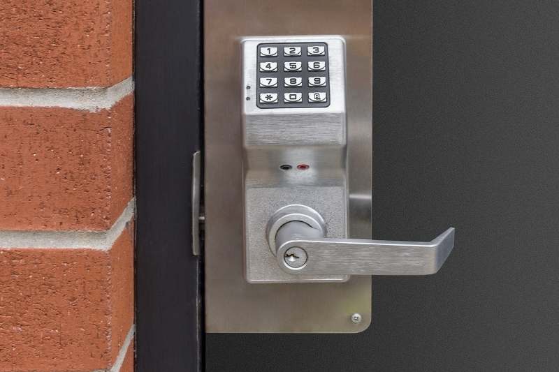 commercial keypad lock installed on door in brick building