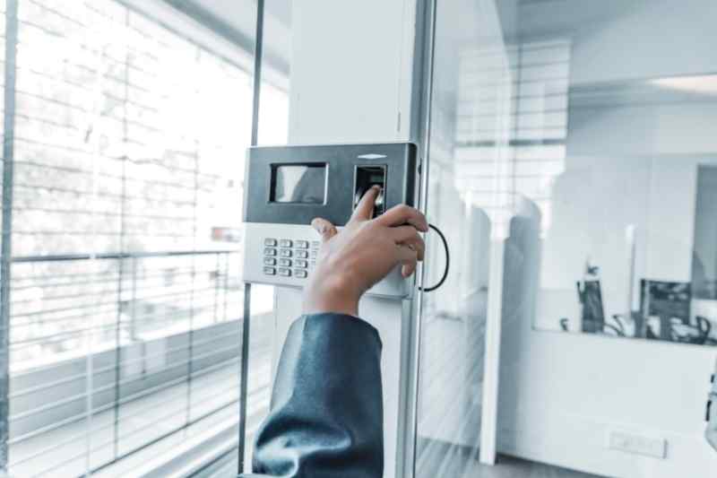 person using commercial smart lock on a glass office door