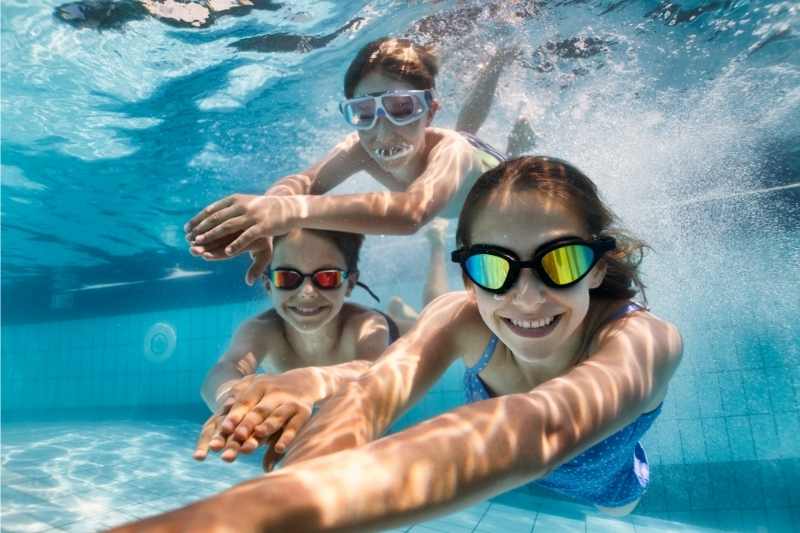 kids swimming and enjoying themselves as a benefit of renting a property with a pool