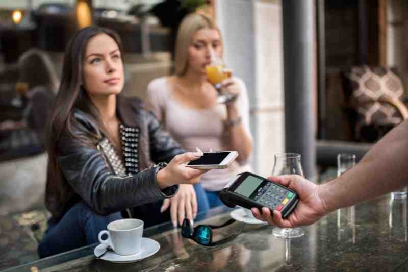 A woman using a credit card NFC reader