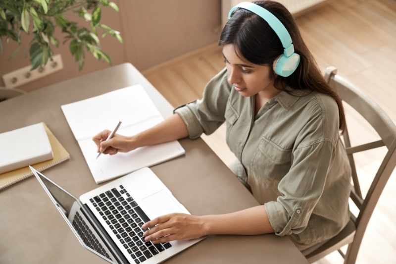 A college student uses the managed WiFi offered at her apartment's student housing design. 