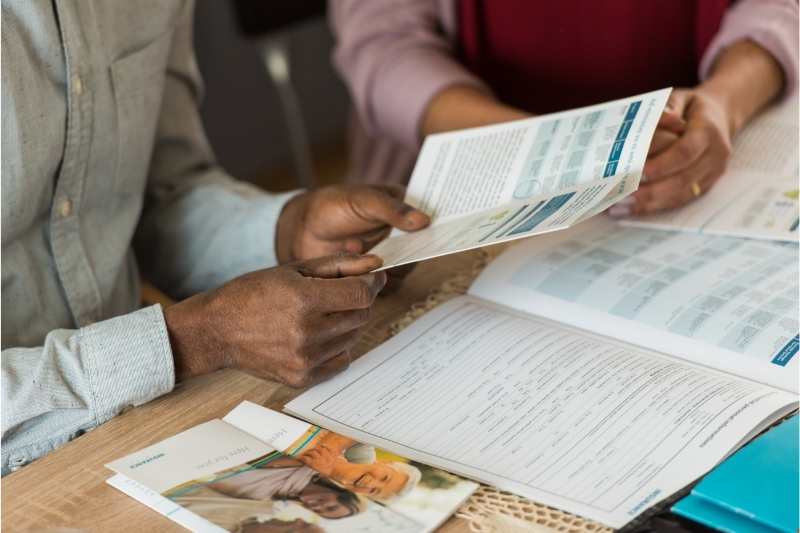 Prospective residents review an information packet at an apartment showing