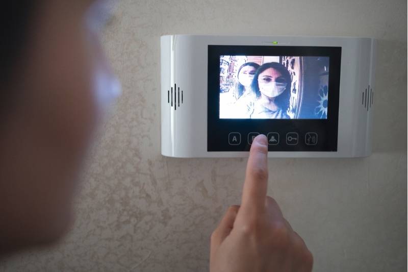 two guests speak with resident over smart doorbell