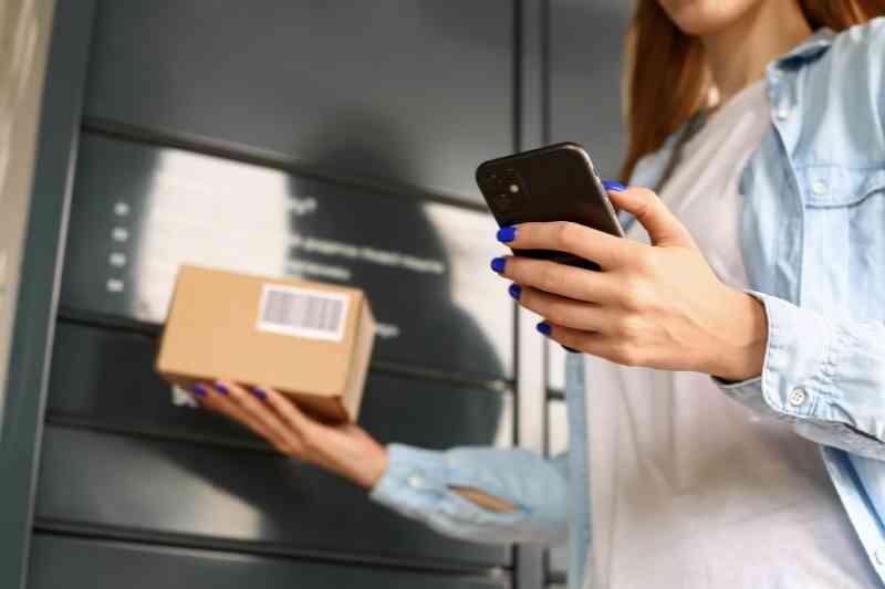 Using smartphone to access automated parcel locker.
