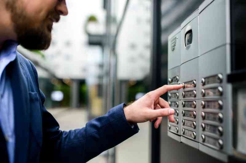 Man using a door buzzer at Chicago apartment.