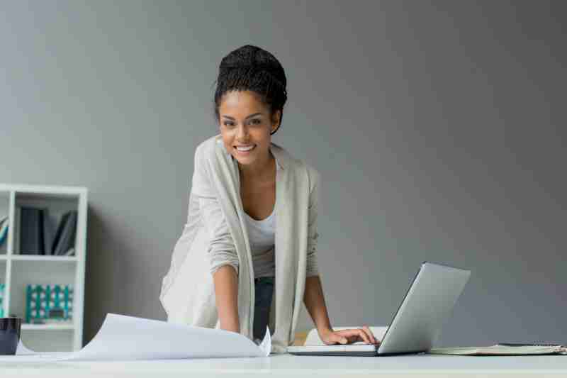 woman standing over a computer using condo management software