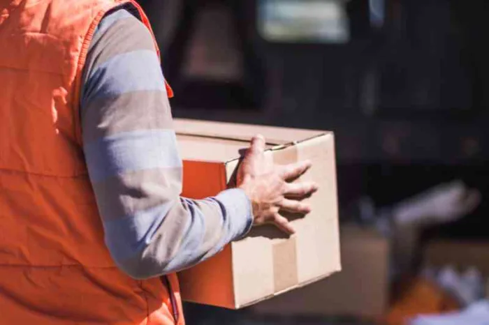 Delivery courier preparing for a delivery to a delivery door.