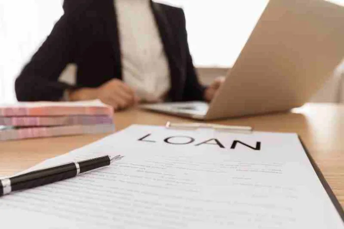 a person applying for a apartment loans with paper that says "loan" and black pen