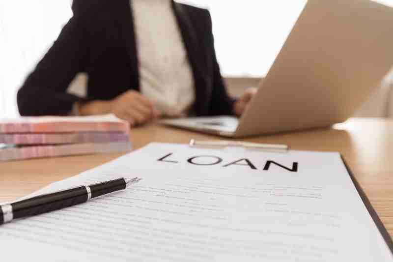 a person applying for a apartment loans with paper that says "loan" and black pen 