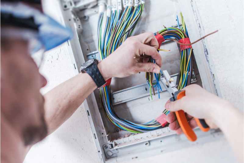 Man hooks up wires for a security system design
