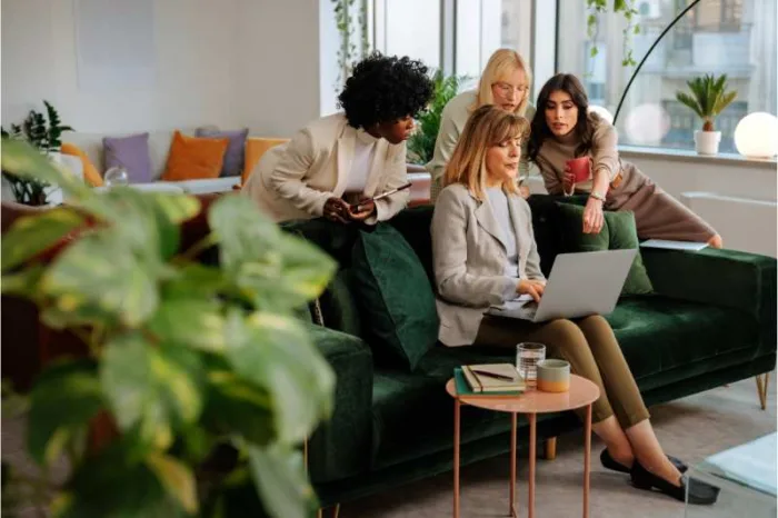 A group of employees enjoy a cozy office set up thanks to workplace management.