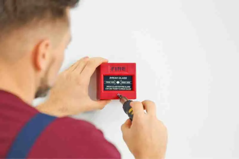Installer placing a new fire alarm system at building.