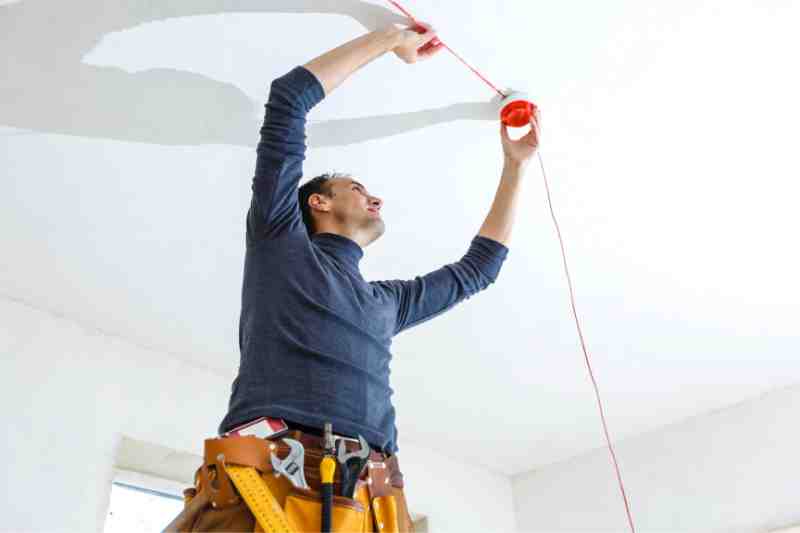 Man installing a new fire alarm system.