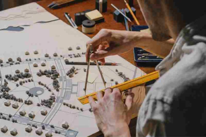 Access control for architects In this photo, a man is using measuring tools to design an architectural project.