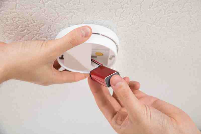 Replacing batteries for different types of smoke detectors.