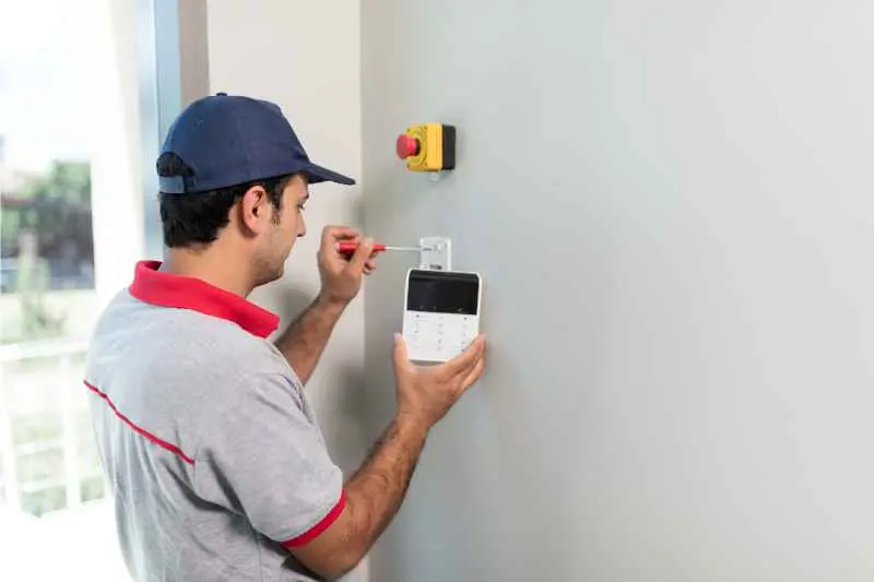 A man installs a security system and could also install a Boston access control system.