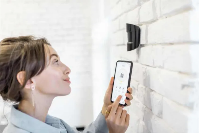 A woman programs her IR sensors with her mobile phone.