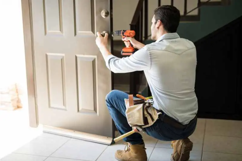 A man installs a pick proof lock.