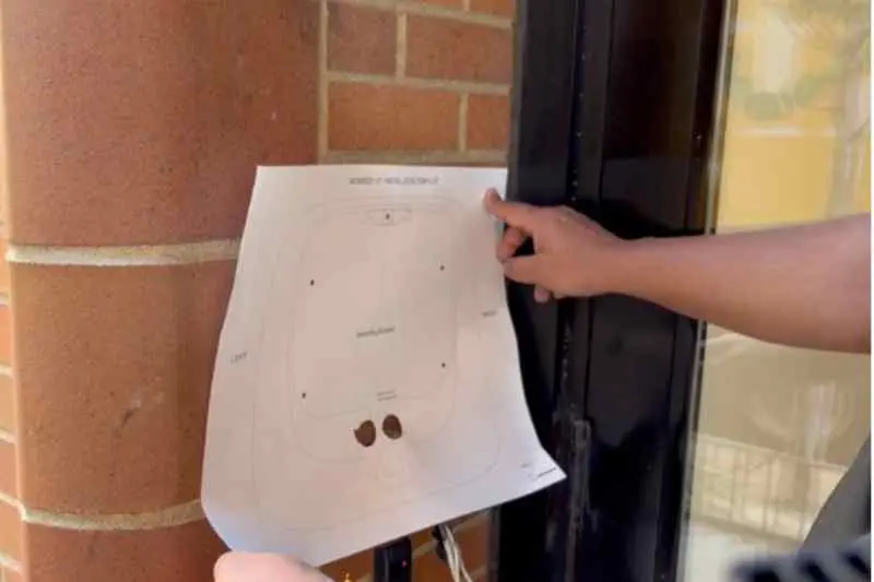 installer marks and drills holes for the new intercom using the mounting template