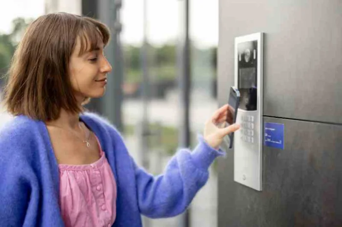 Woman using NFC tags in real estate to access a building.