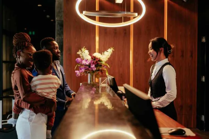 Woman checking in a family with a front desk solution.