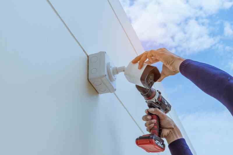 Installer placing commercial security cameras.