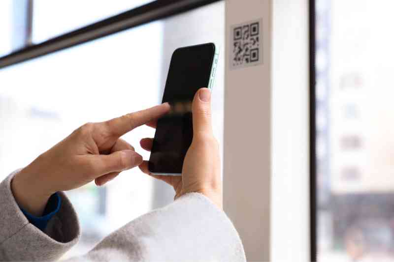 Guest scanning a QR code at a building.