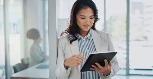 woman in office holding tablet and smiling