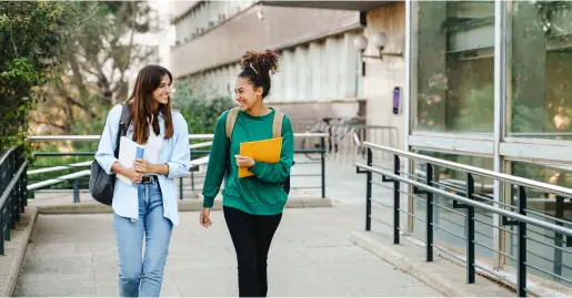 Two students walking past building