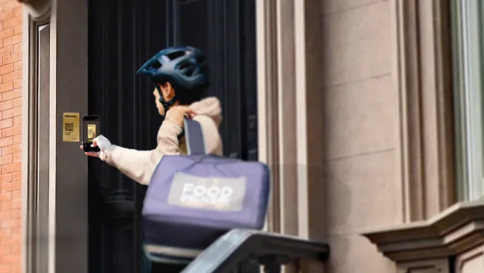 delivery person scanning ButterflyMX Qr Code Intercom in front of brownstone residential building
